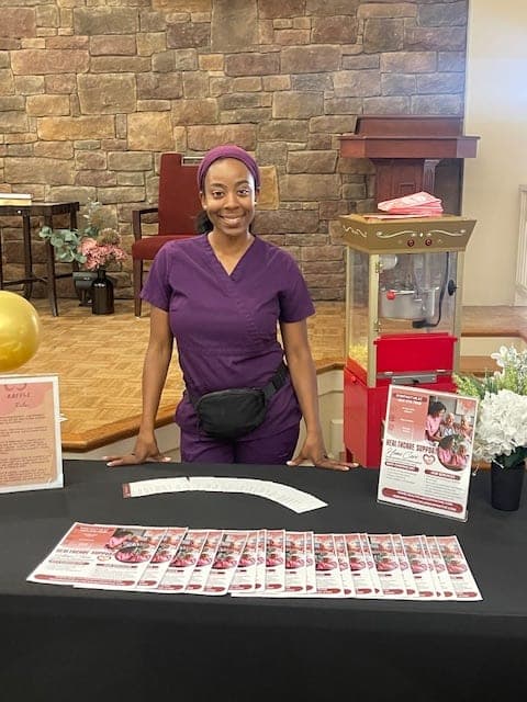 A Healthcare Support caregiver at the agency's table at the Pruitt Christian City Community Resource Event